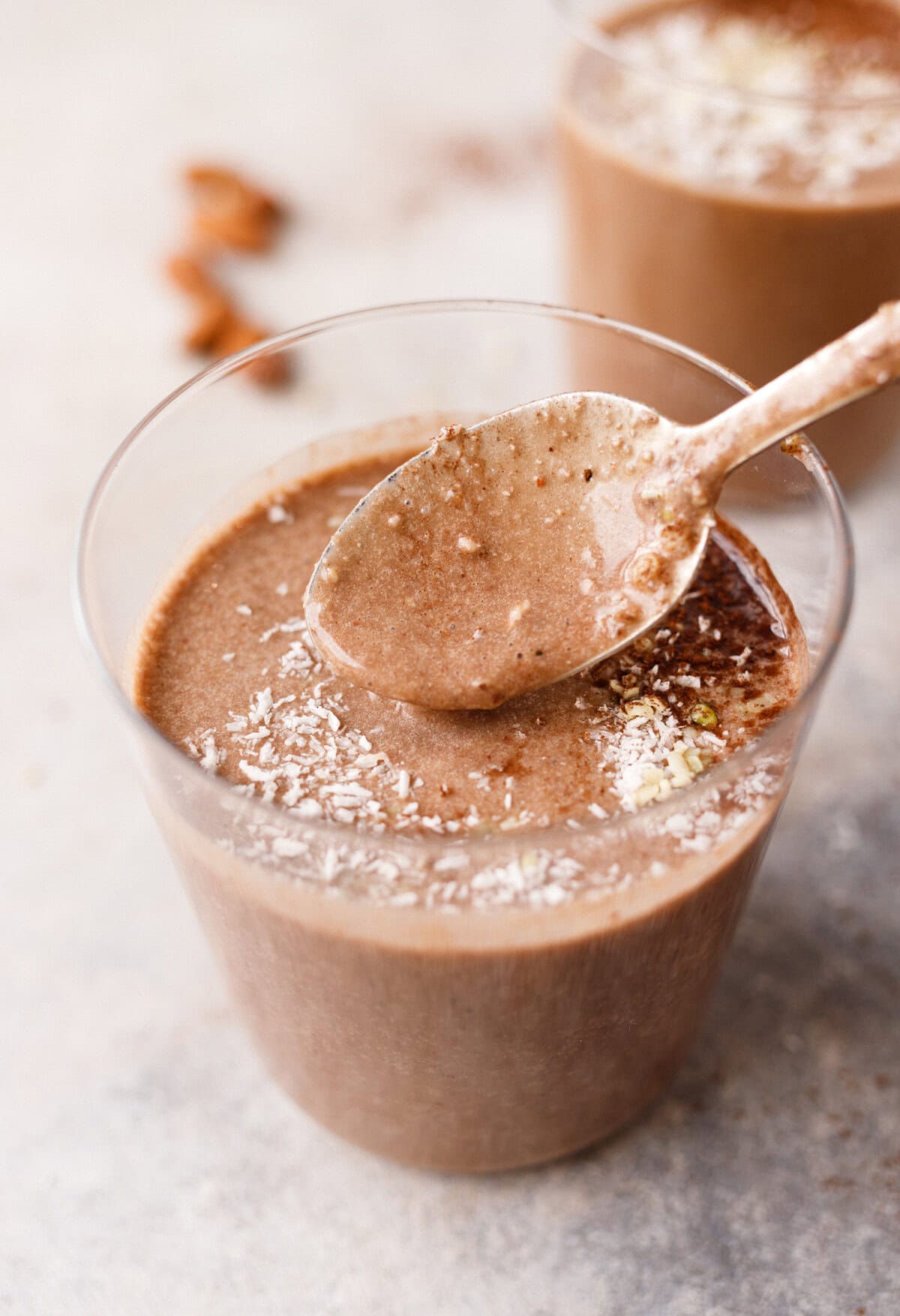 Thick almond coffee protein smoothie texture on spoon showing creamy consistency with cocoa and coconut