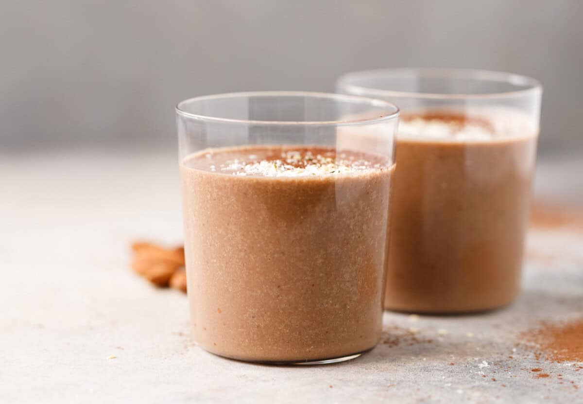 Almond coffee protein smoothie in glasses with creamy texture made with coffee, banana and almond milk