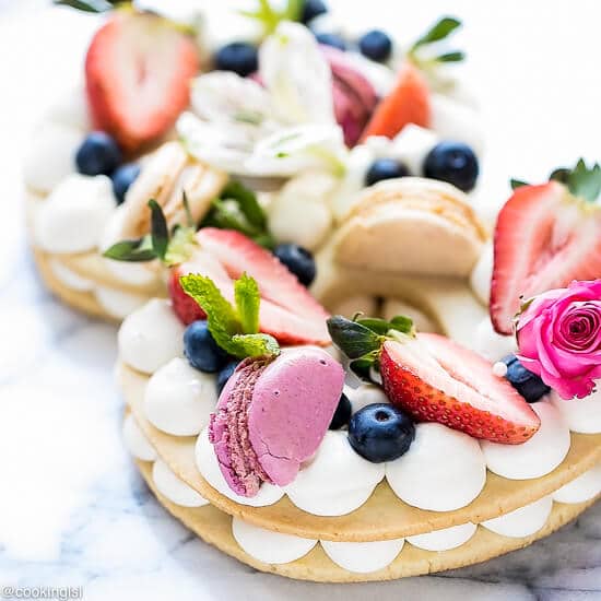 Cream Tart Recipe - New Cake Trend on a platter, topped with macarons, strawberries, flowers, meringue cookies, berries.