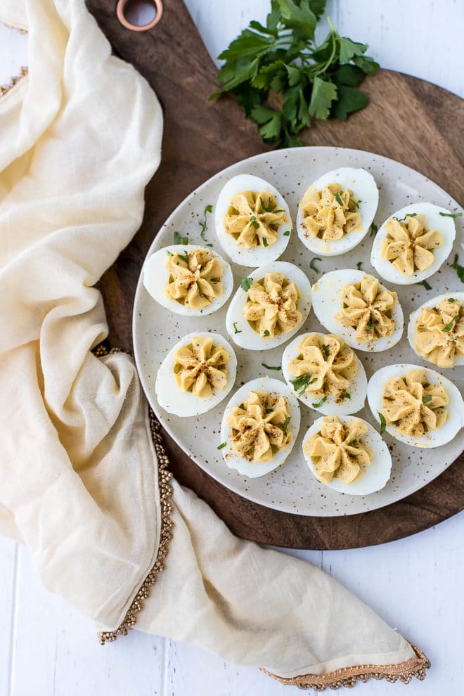 Hummus Deviled Eggs on a cutting board with a towel on the side