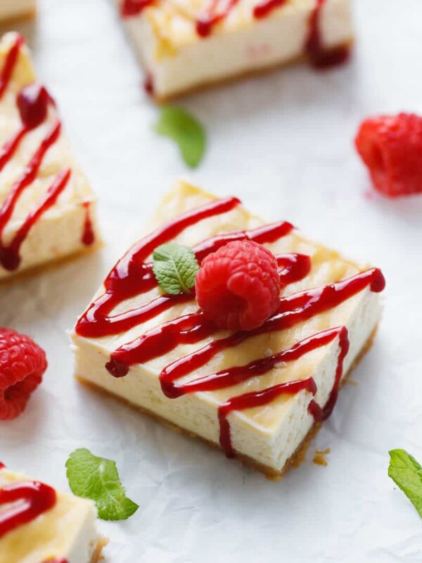 Raspberry Cheesecake Bars - Sugar-Free on parchment paper with fresh raspberries