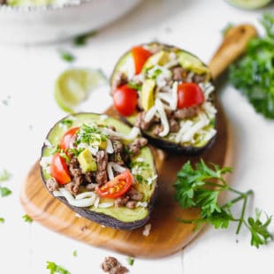 Taco Stuffed Avocado {Keto, Low-Carb} on a wooden board