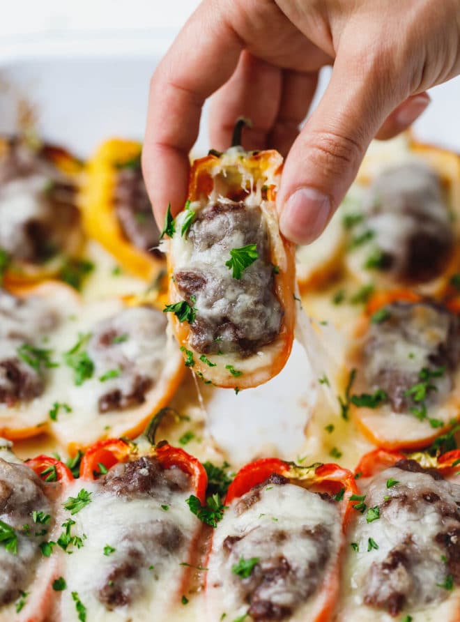 Low-Carb, Keto Cheeseburger Stuffed Peppers Recipe- a hand holding mini pepper
