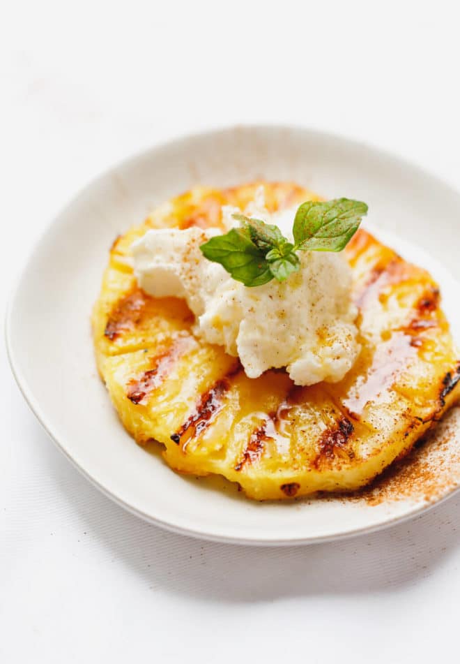 Easy Grilled Pineapple on a plate with mascarpone whipped cream