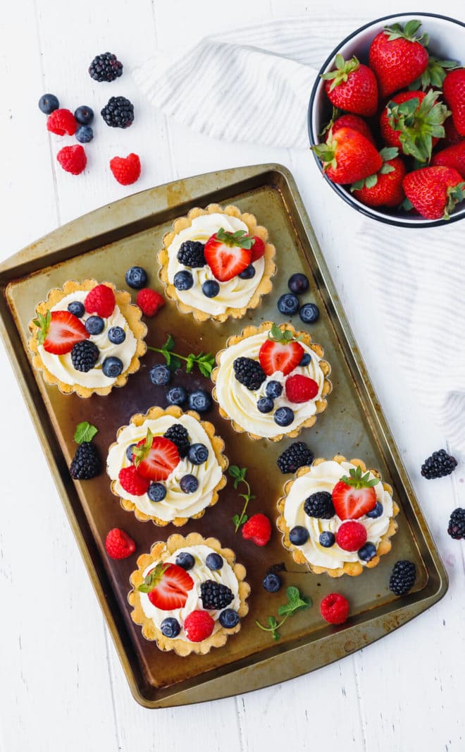 Low-Carb, Keto Tarts With Berries And Mascarpone Cream on a baking sheet