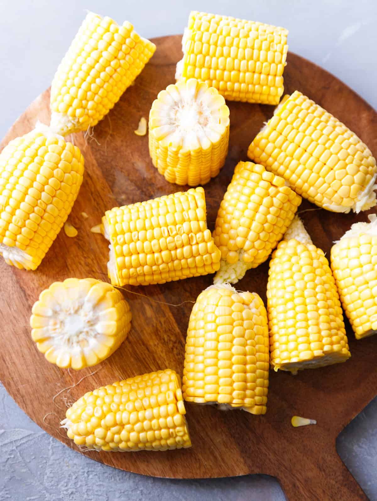 Quartered corn on the cob on a cutting board