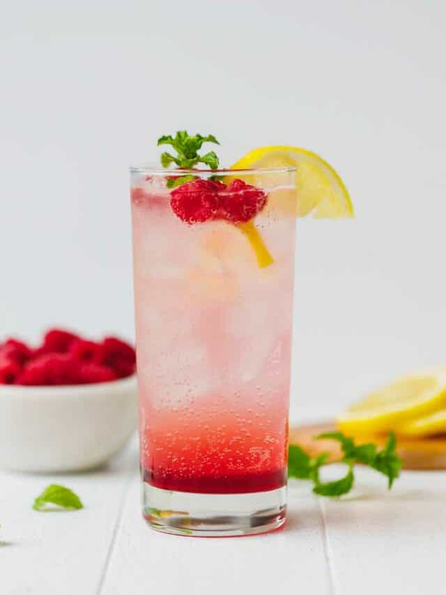 Raspberry lemonade in tall glass with lemon slice
