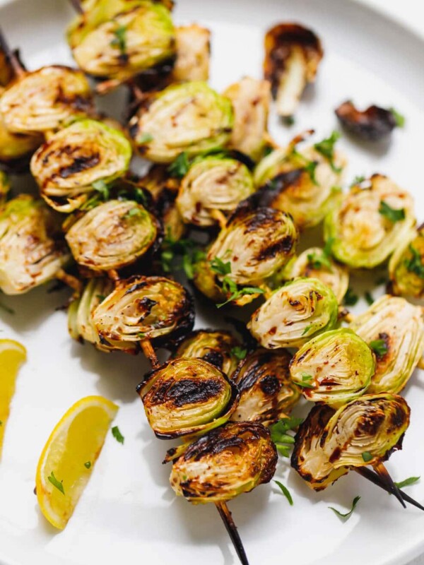 Charred grilled brussel sprouts on a skewer on a plate