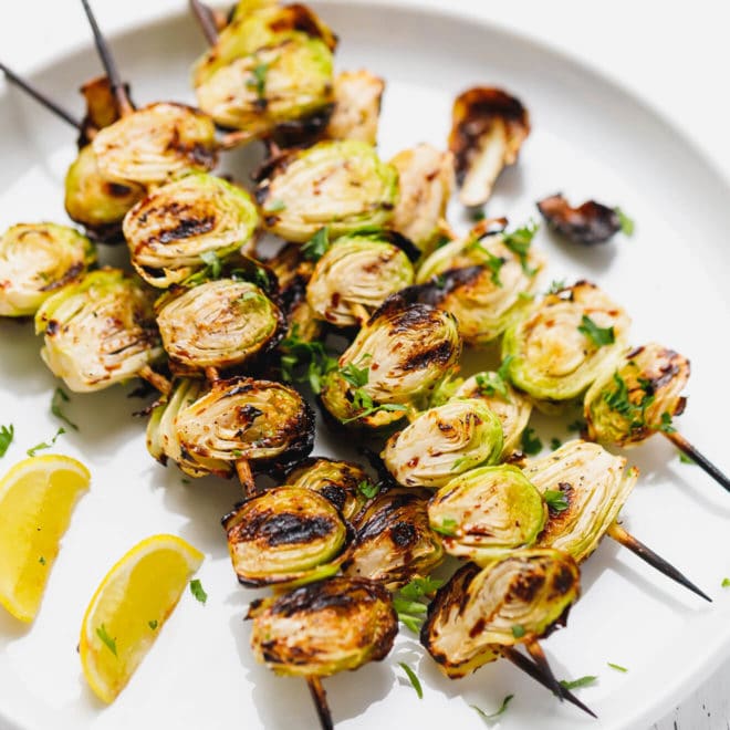 Grilled brussel sprouts on skewers on a platter
