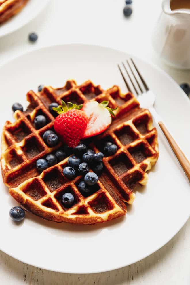 Keto waffles on a white plate with berries