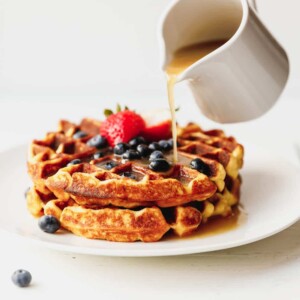 Keto waffles on a plate with Sugar-free Syrup and berries