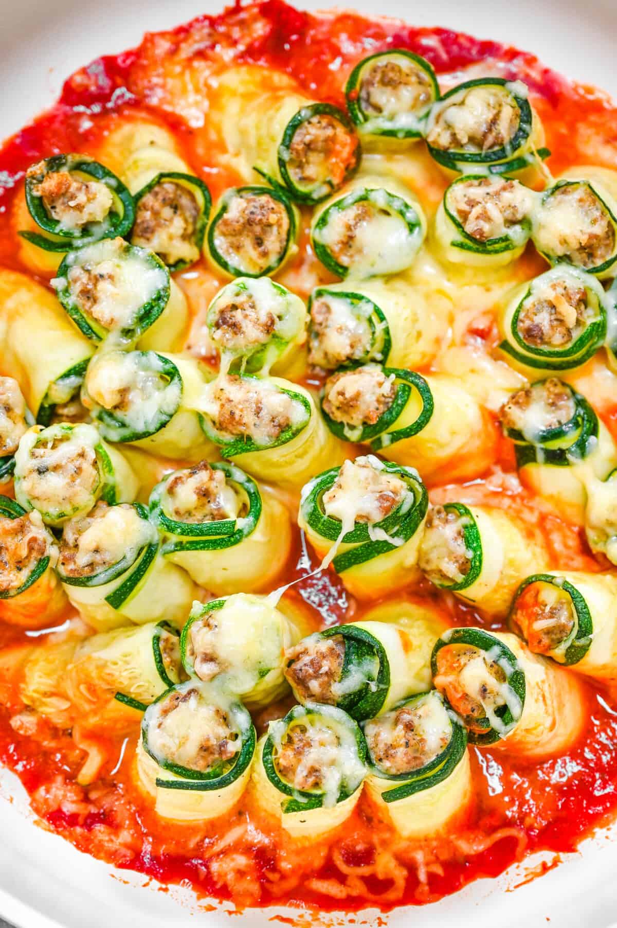 A white pan with zucchini lasagna roll ups