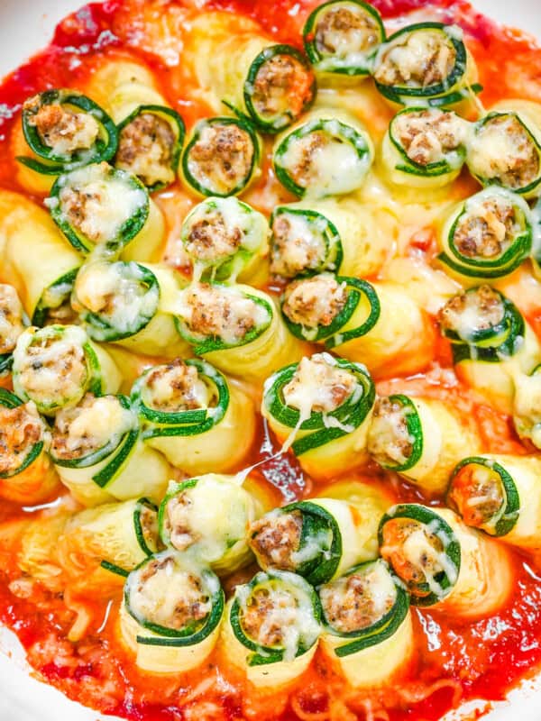 A white pan with zucchini lasagna roll ups