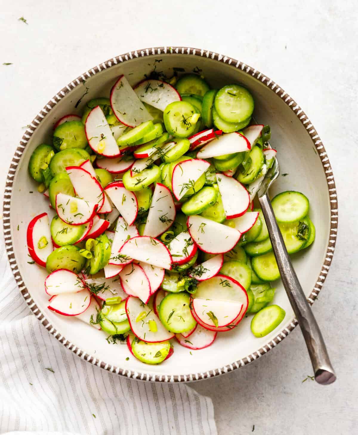 cucumber radish dill salad top view with sliced cucumbers radishes and green onions