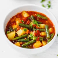 Green bean soup with potatoes in a white bowl