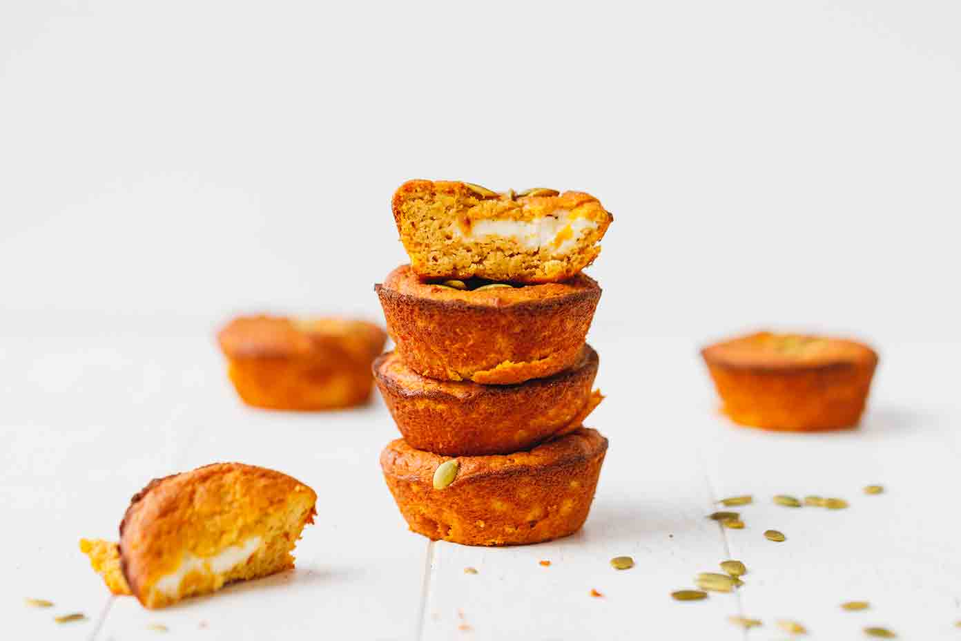 Low-carb pumpkin muffins with cream cheese center stacked on each other