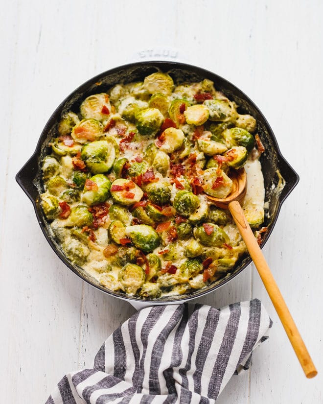 Cheesy Creamy Brussel Sprouts With Bacon in a cast iron skillet