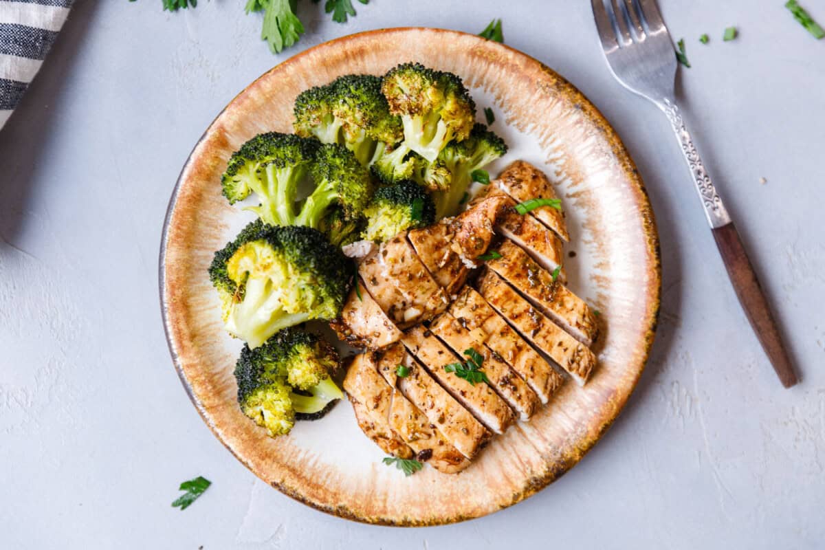 A plate with broccoli and sliced balsamic chicken breast.