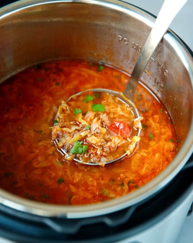 A ladle with Keto cabbage soup inside