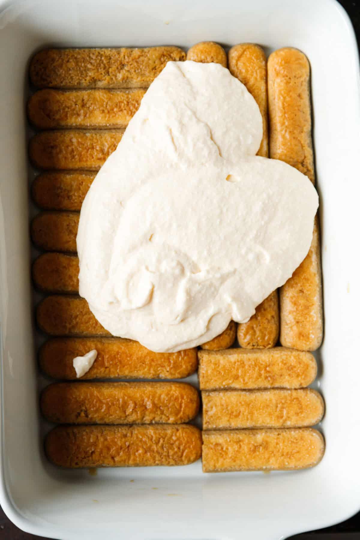 A dish with lady fingers and mascarpone cream on top