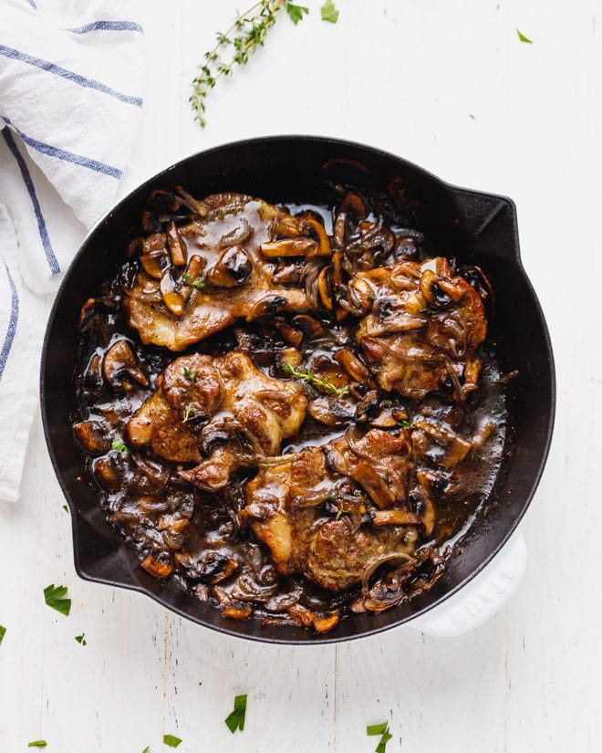 Pork steak with mushrooms and onions in a pan