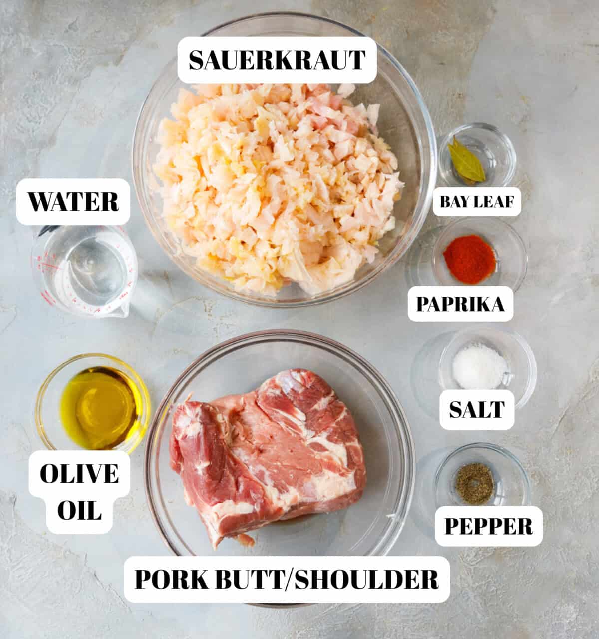 Clear glass bowls with ingredients for pork and sauerkraut