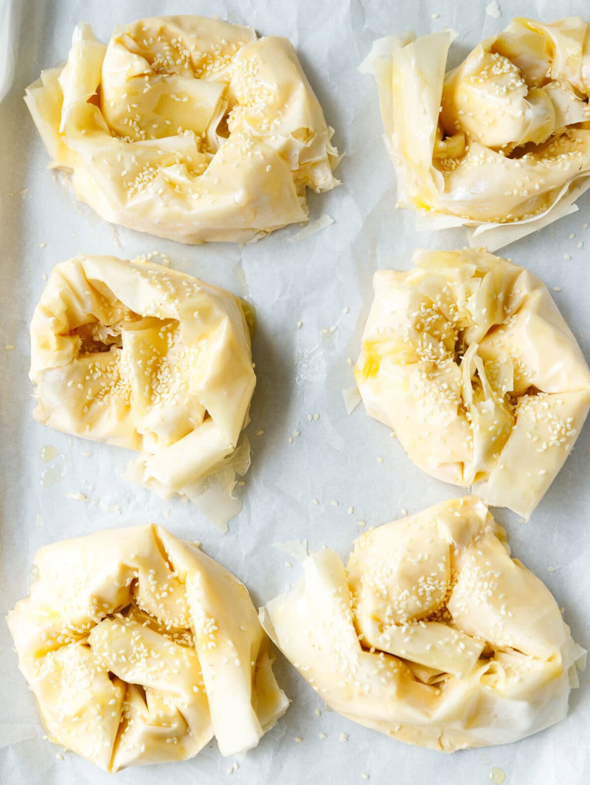 Banitsa phyllo dough swirls topped with sesame seeds before baking
