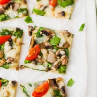 Easy Cauliflower Pizza With Spinach And Mushrooms on a cutting board