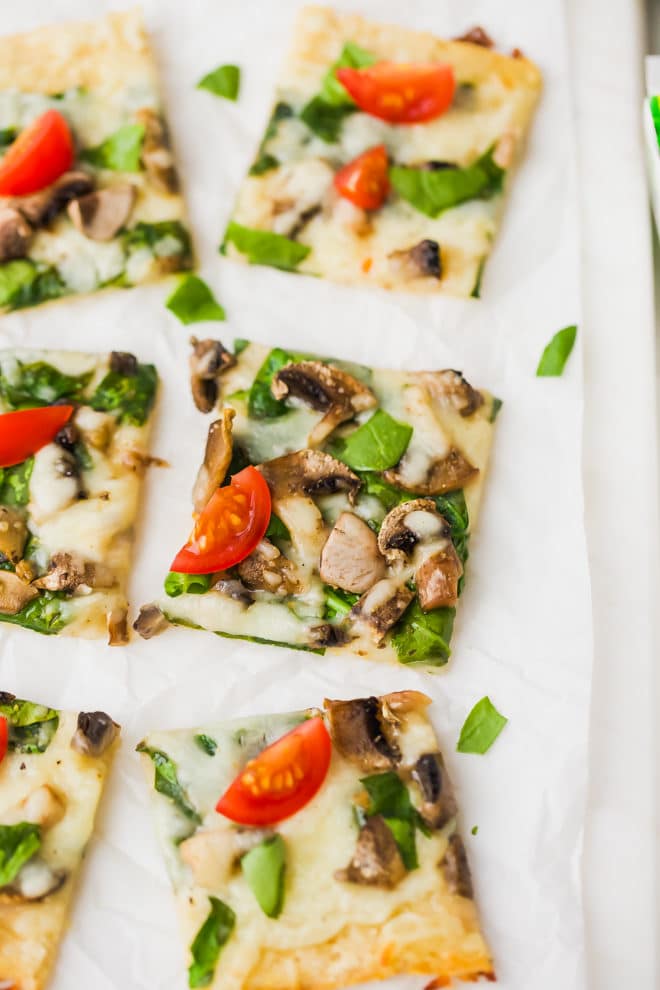 Easy Cauliflower Pizza With Spinach And Mushrooms on a cutting board