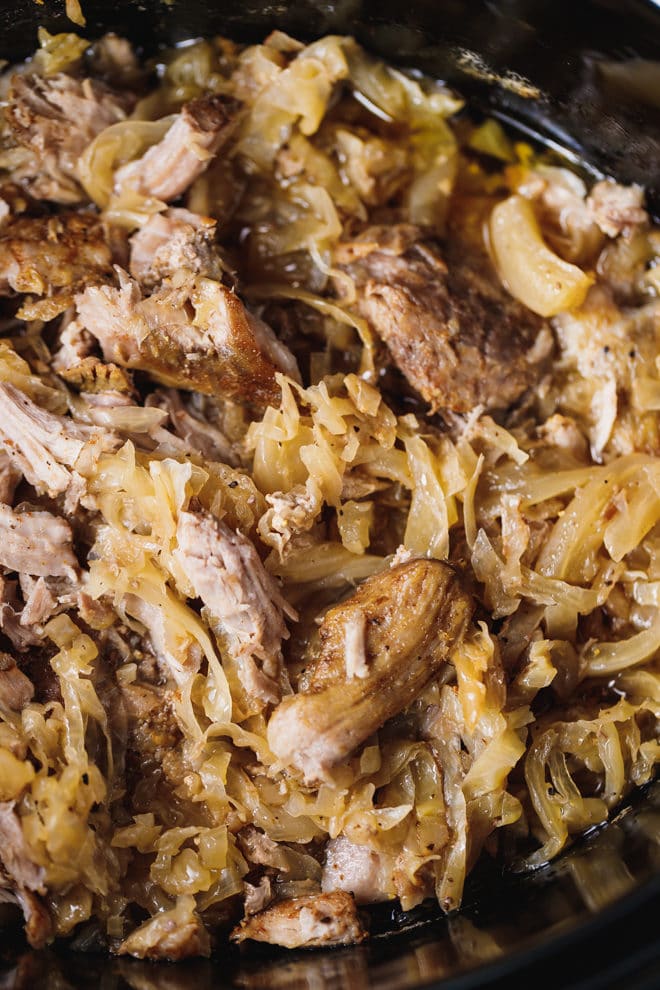 Pork and sauerkraut in a black slow cooker