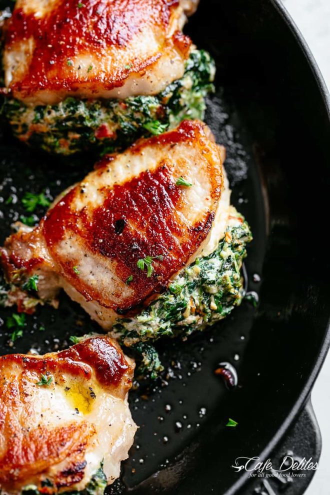 Spinach stuffed pork chops in a cast iron skillet