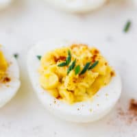 Deviled egg on a white plate with paprika on top