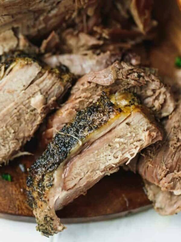 Slow cooked leg of lamb sliced on a cutting board