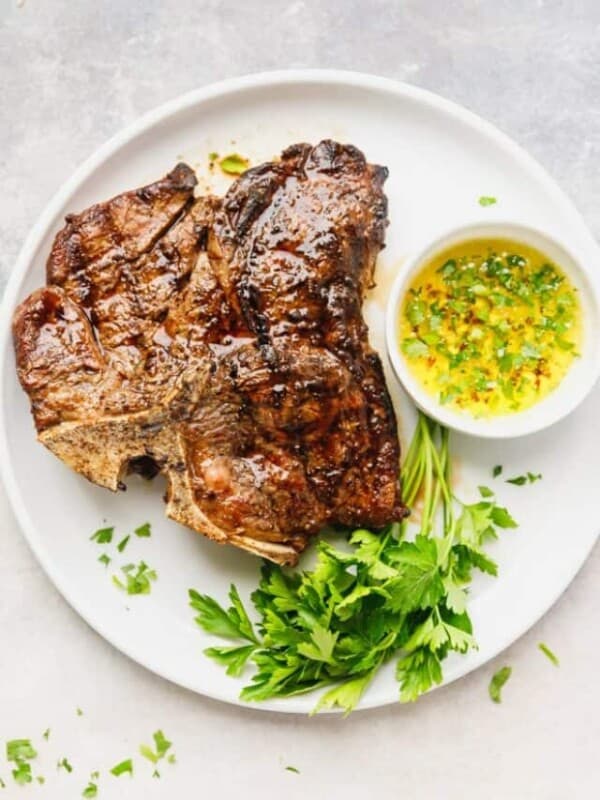 Grilled t bone steak on a white plate