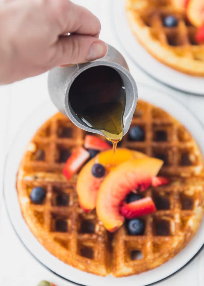 Yeasted waffles with maple syrup drizzling on top