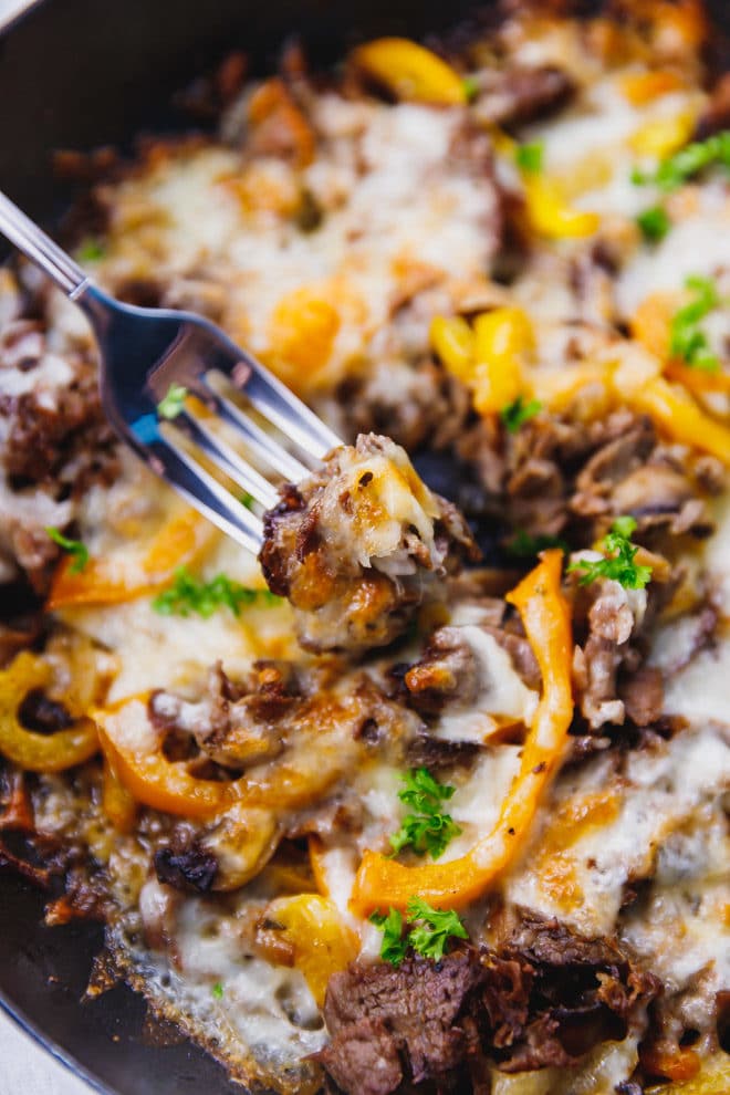 A fork full of cheesy Philly Cheesesteak