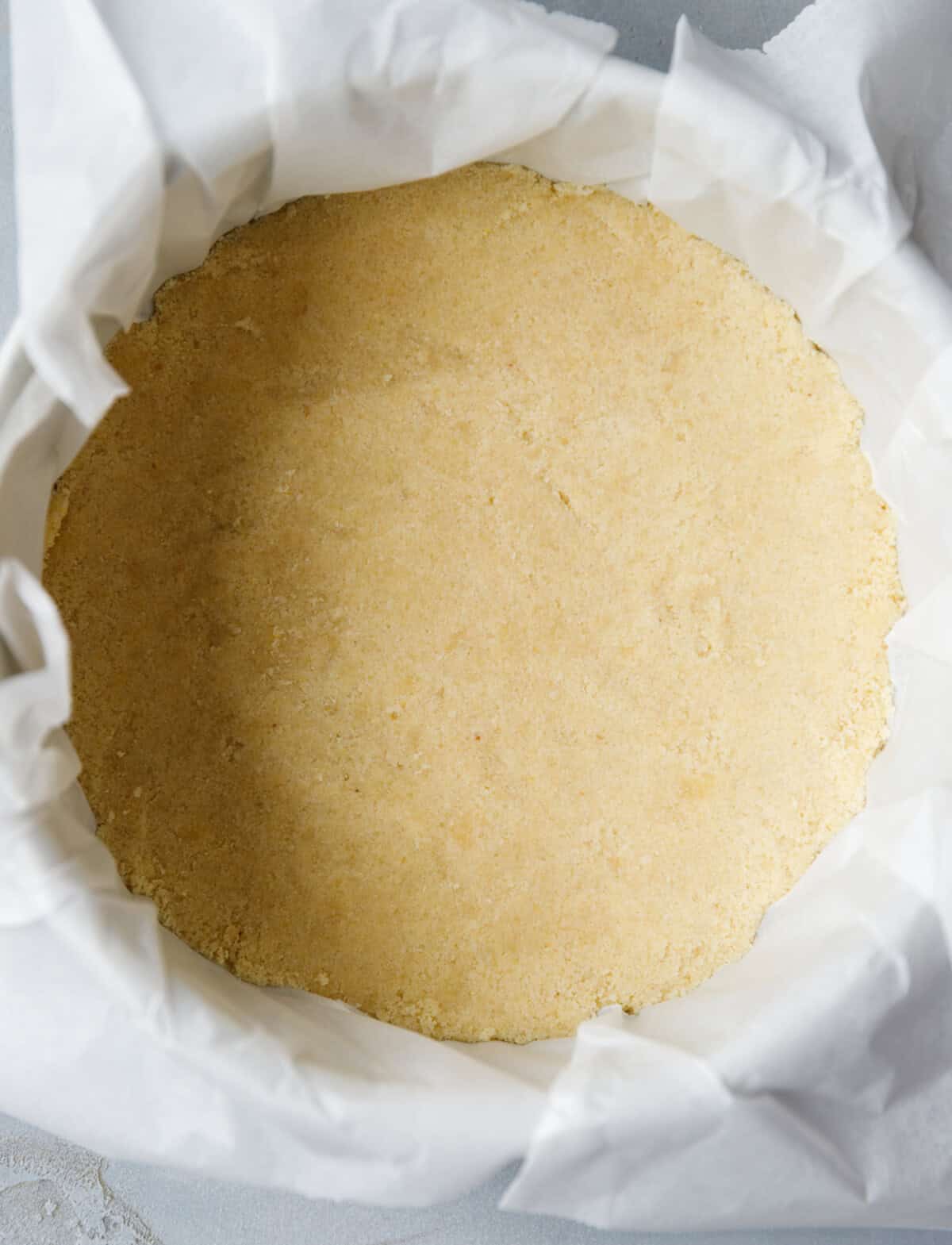 low carb cheesecake crust made with almond flour evenly pressed into pan