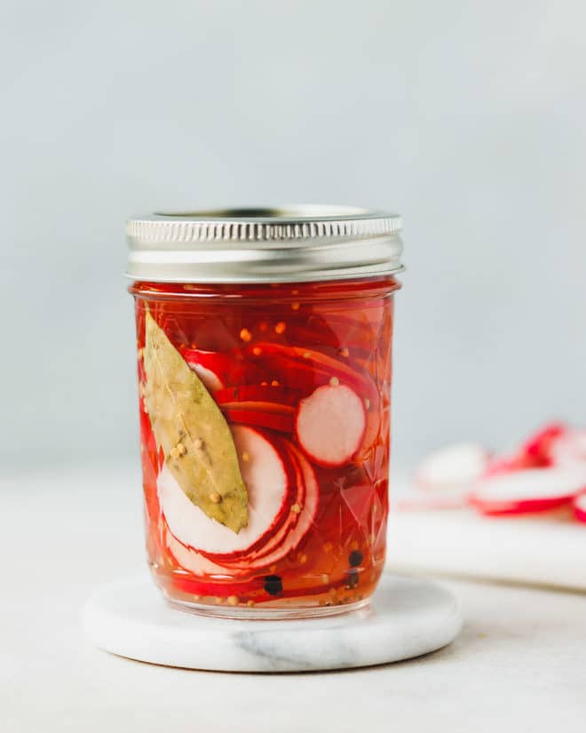 Pickled pink radishes in a small Ball jar