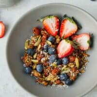 Keto granola with strawberries in a gray cereal bowl