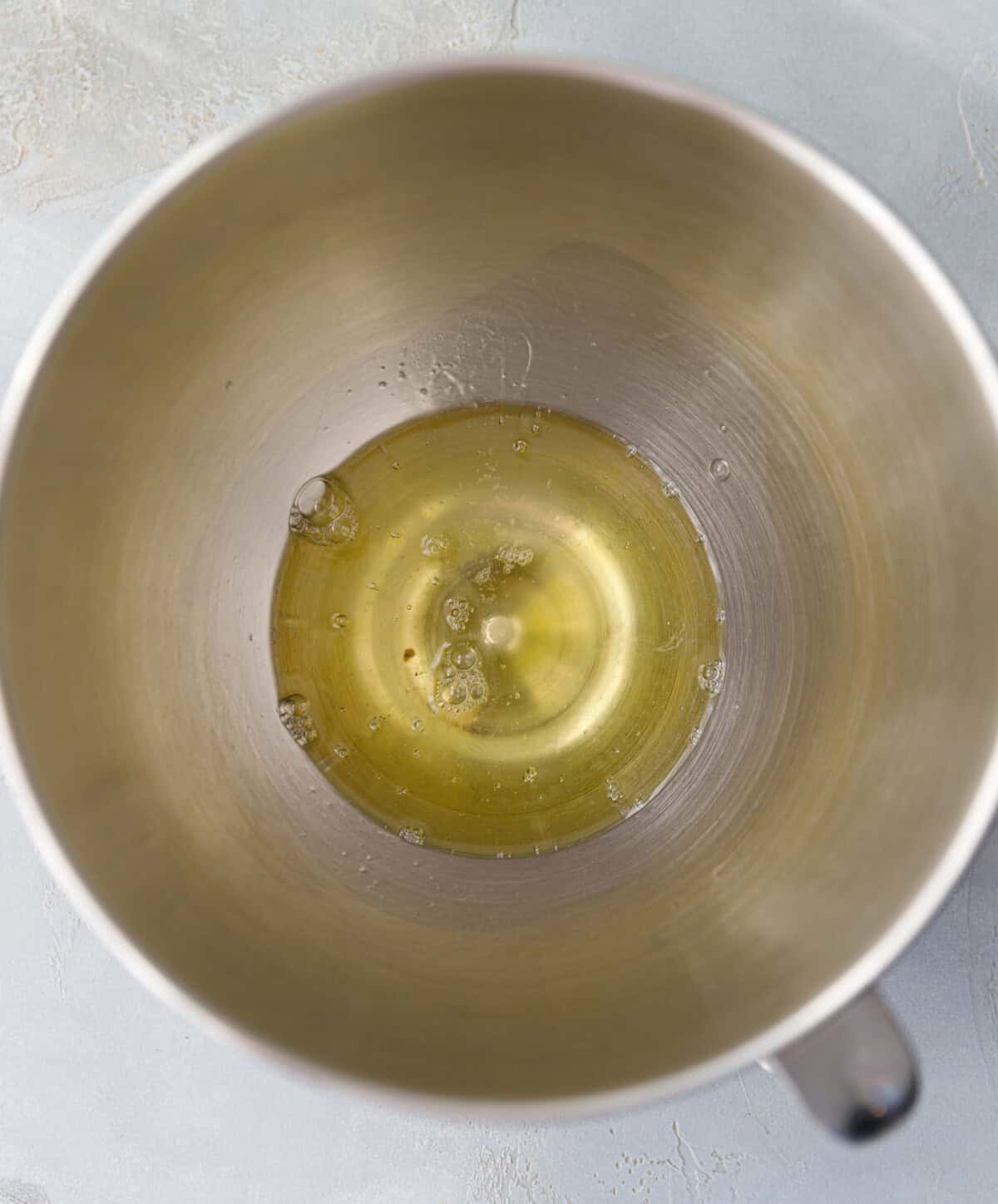 Raw egg whites in a stainless steel mixing bowl, ready to be whipped for pumpkin magic custard cake.