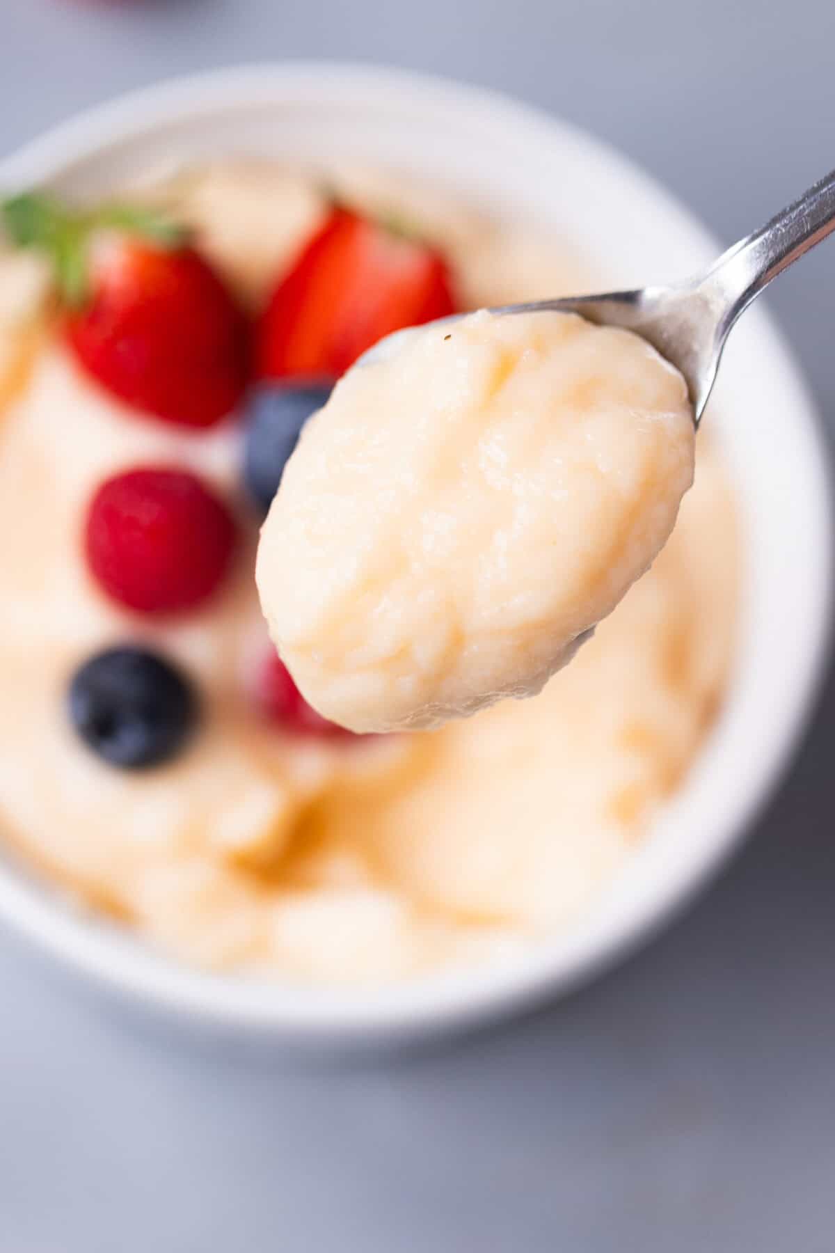 A ramekin with homemade vanilla custard and a spoon full of it.