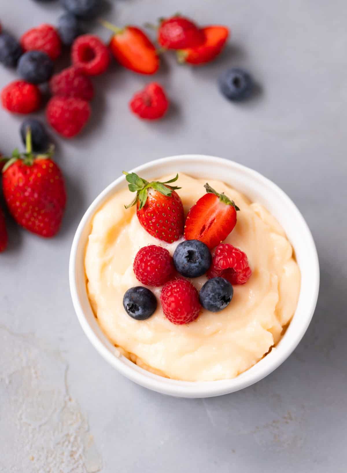 Custard served chilled with fresh fruit on top.