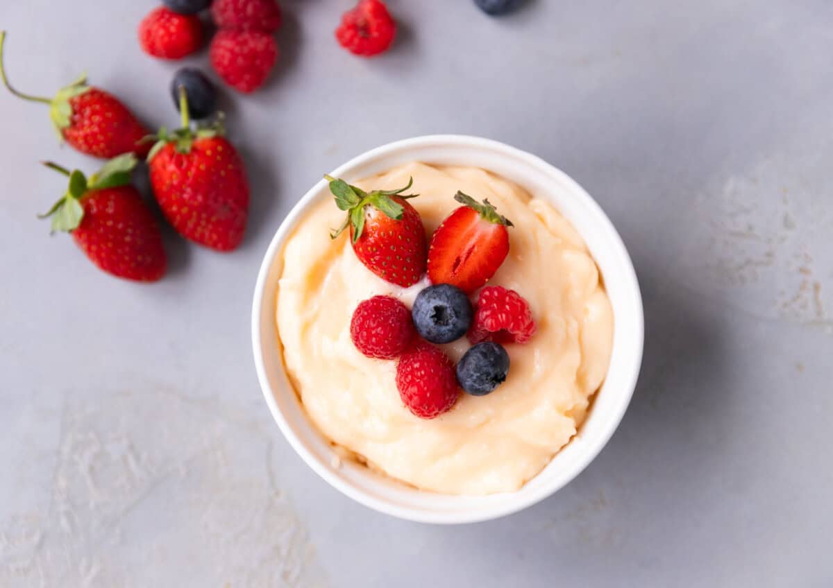 Homemade custard served chilled with fresh fruit on top.