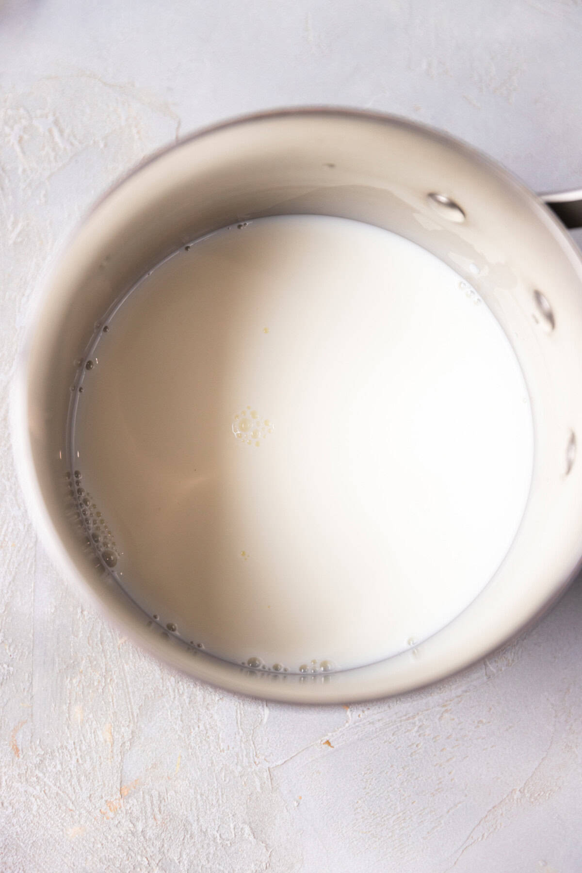 A saucepan with warmed up with milk and sugar for homemade custard.