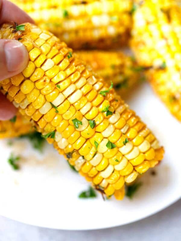 A hand holding corn on the cob