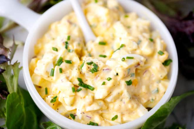 classic egg salad topped with chives in a bowl