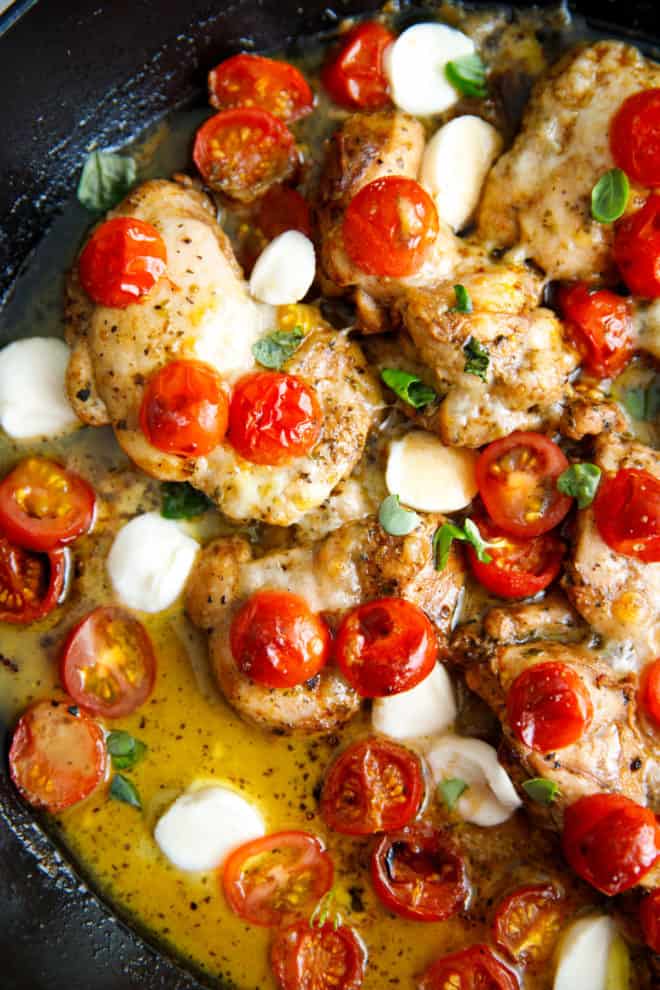 A pan qith chicken thighs fresh mozzarella and cherry tomatoes