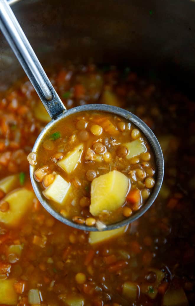 A ladle filled with Easy lentil soup with potatoes
