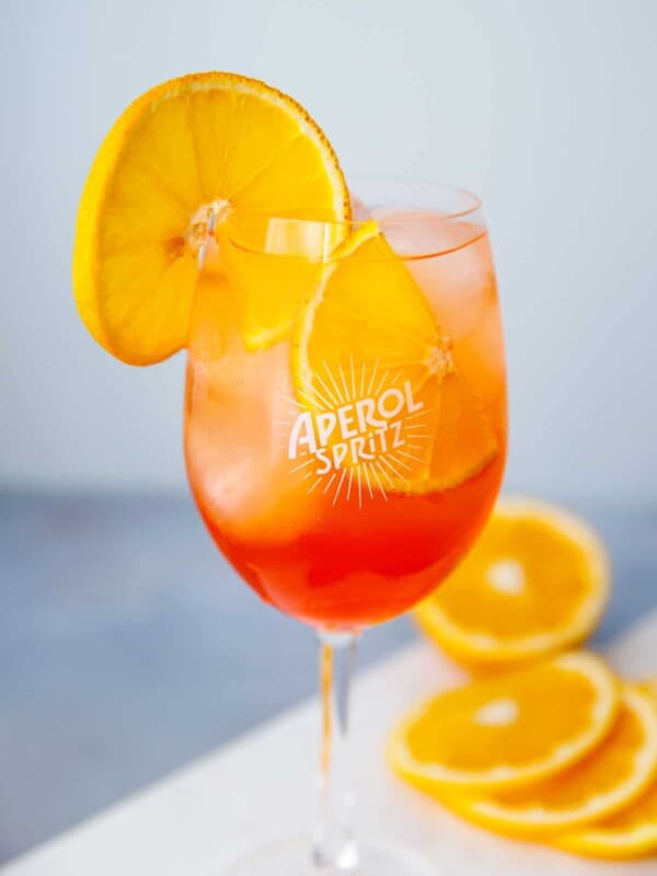 Aperol spritz in a clear wine glass with an orange slice