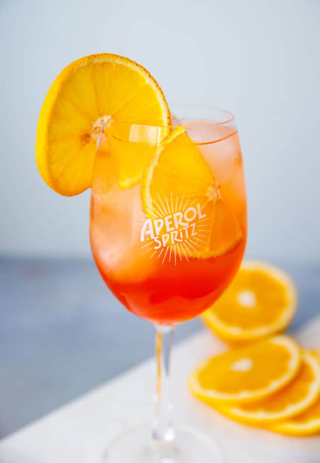 Aperol spritz in a clear wine glass with an orange slice